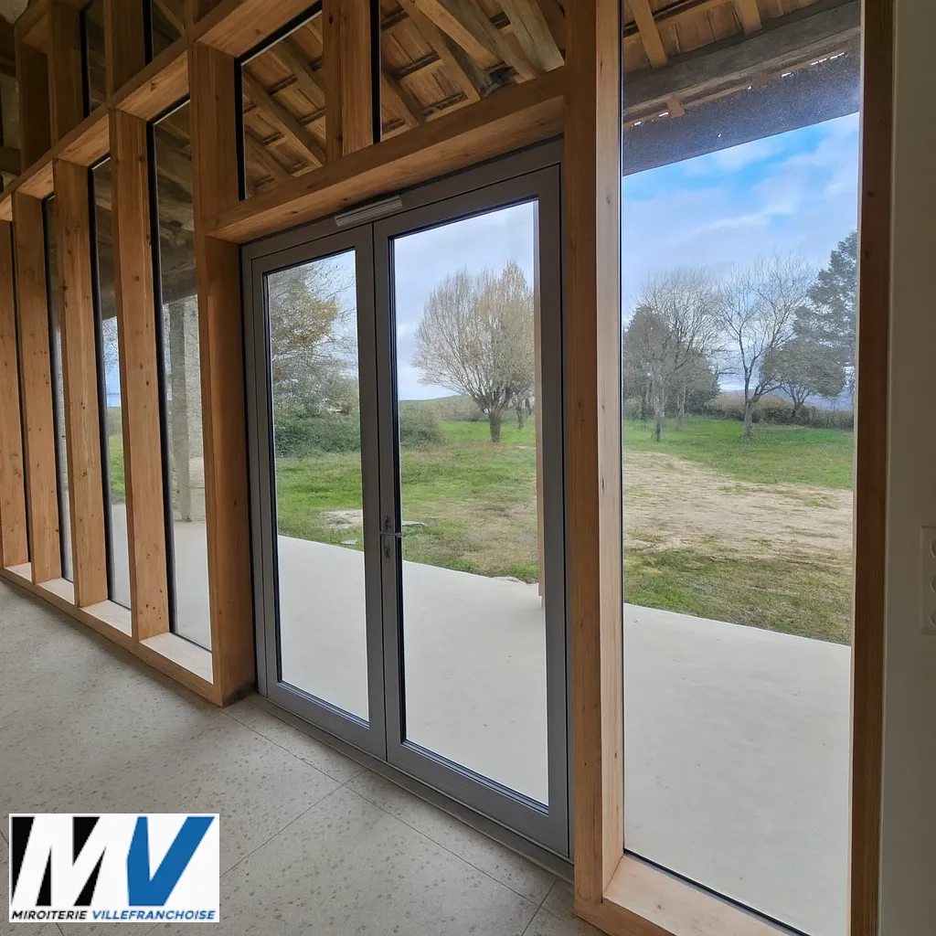 Rénovation de grange en Aveyron : L'alliance du mur rideau TECHNAL et du charme de l'ancien